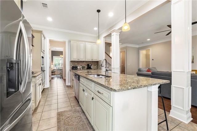 kitchen with visible vents, light tile patterned flooring, ornate columns, a sink, and appliances with stainless steel finishes