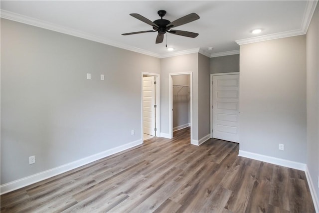 363 Lightness Dr, Auburn, AL 36832 - unfurnished bedroom featuring baseboards, ornamental molding, a walk in closet, and wood finished floors