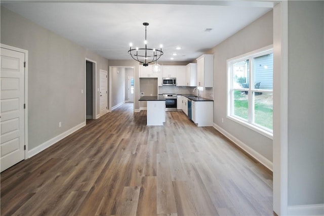 363 Lightness Dr, Auburn, AL 36832 - kitchen with white cabinets, dark countertops, appliances with stainless steel finishes, an inviting chandelier, and a sink