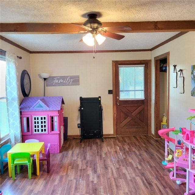 rec room featuring hardwood / wood-style floors, a textured ceiling, ceiling fan, and crown molding