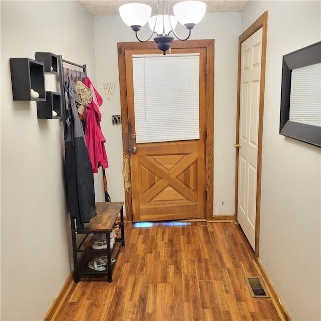 doorway with a chandelier and hardwood / wood-style flooring