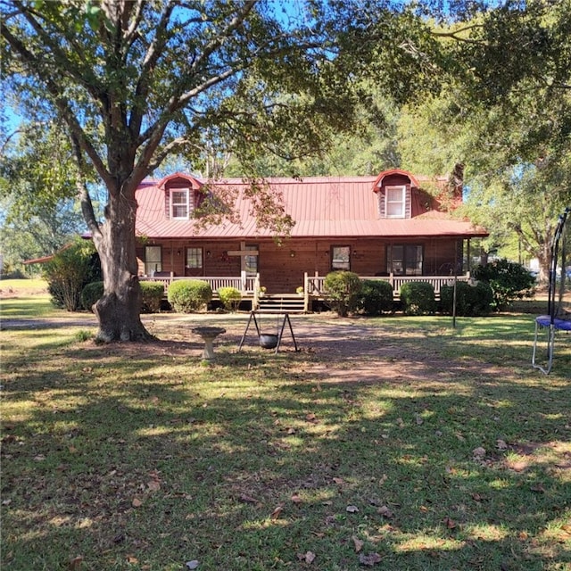 view of front of house with a trampoline and a front yard