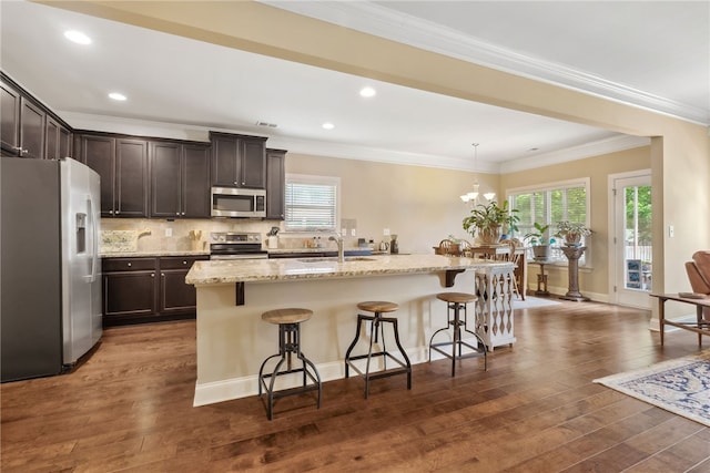 1107 Hampstead Ln, Opelika, AL 36801 - kitchen with appliances with stainless steel finishes, dark brown cabinets, dark wood finished floors, a breakfast bar area, and healthy amount of natural light