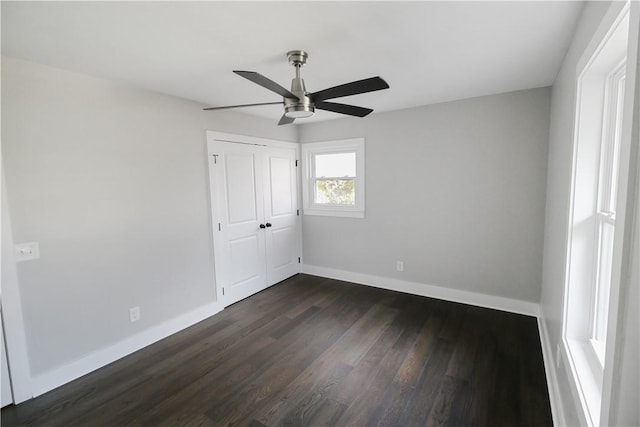 unfurnished bedroom featuring ceiling fan, dark wood-type flooring, and a closet