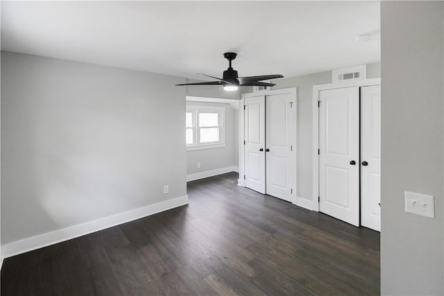 unfurnished bedroom with ceiling fan and dark hardwood / wood-style flooring