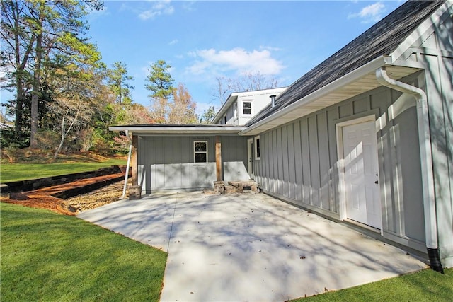 view of side of home with a patio area and a yard