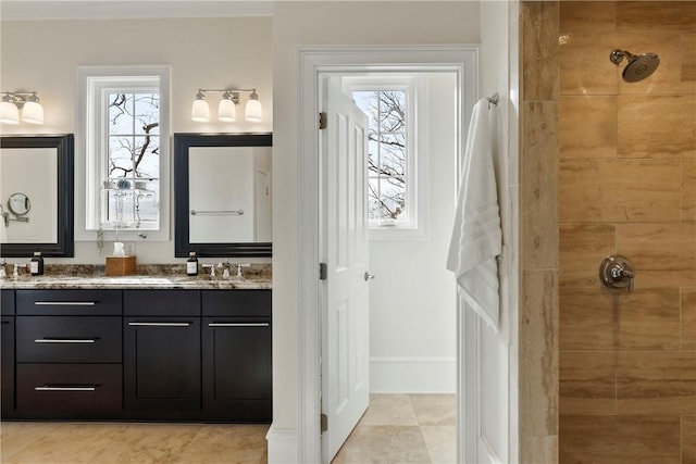 bathroom with tile patterned flooring, vanity, and tiled shower