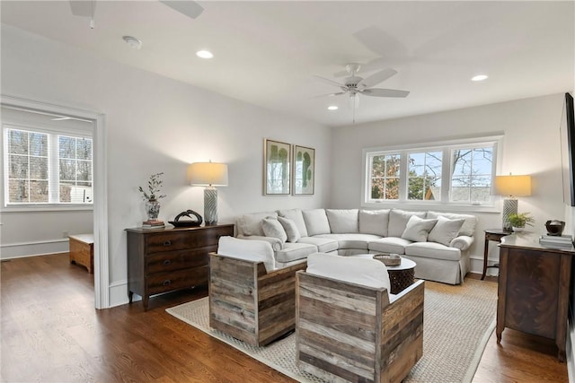 living room featuring dark wood-type flooring, a wealth of natural light, and ceiling fan