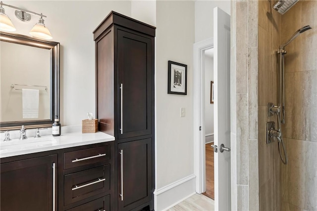 bathroom with vanity, hardwood / wood-style floors, and a tile shower