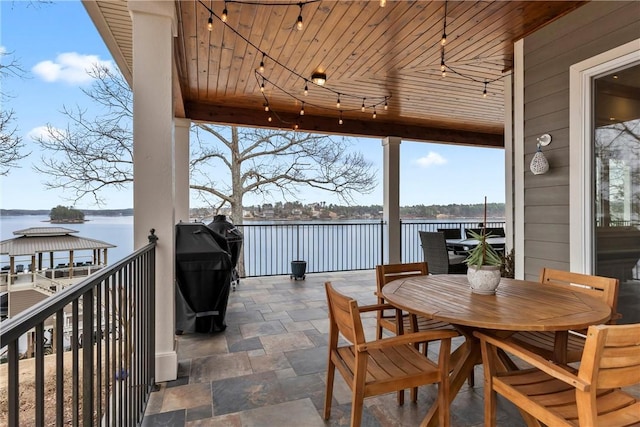 exterior space with area for grilling and a water view