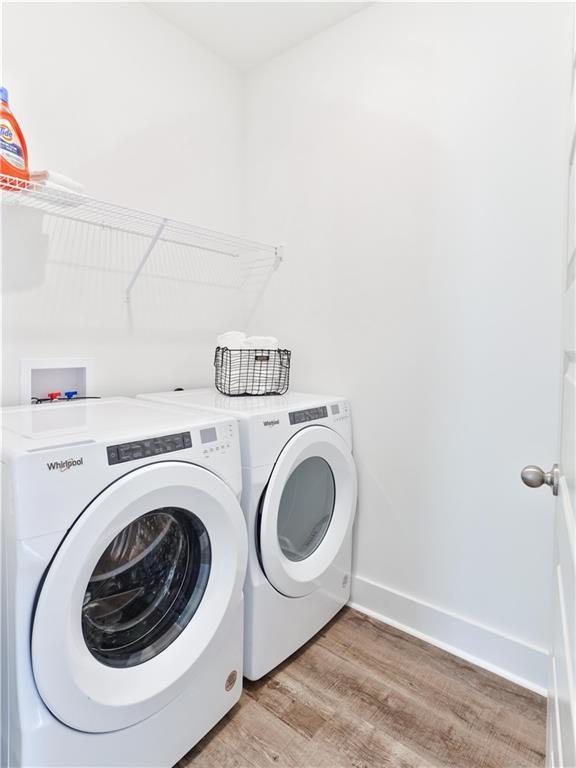 0104 Bradley Ln, Auburn, AL 36830 - laundry area with light wood-style floors, washer and dryer, and baseboards