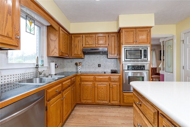 2500 Ridge Rd, Opelika, AL 36801 - kitchen featuring brown cabinets, under cabinet range hood, a sink, and stainless steel appliances