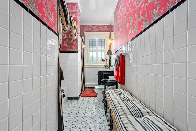 bathroom featuring toilet, tile walls, and ornamental molding