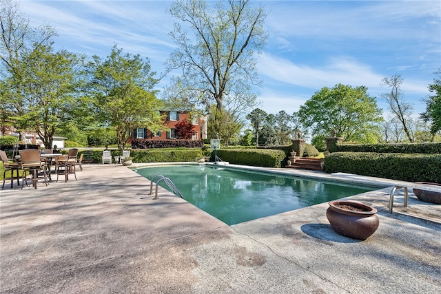 view of swimming pool featuring a diving board and a patio area