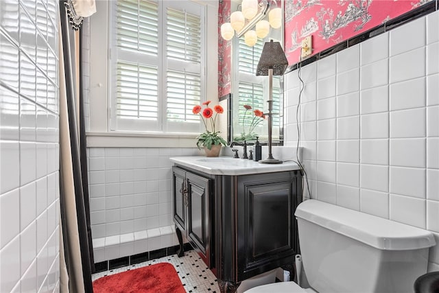 bathroom with tile patterned flooring, vanity, tile walls, and toilet