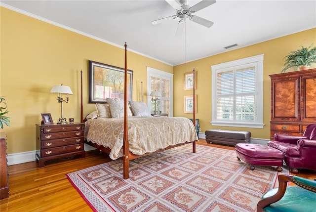 bedroom featuring ceiling fan, wood-type flooring, and ornamental molding