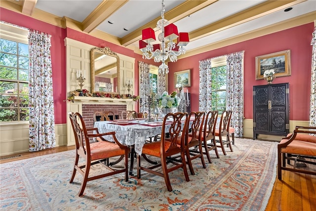 dining room featuring beamed ceiling, hardwood / wood-style flooring, a wealth of natural light, and an inviting chandelier