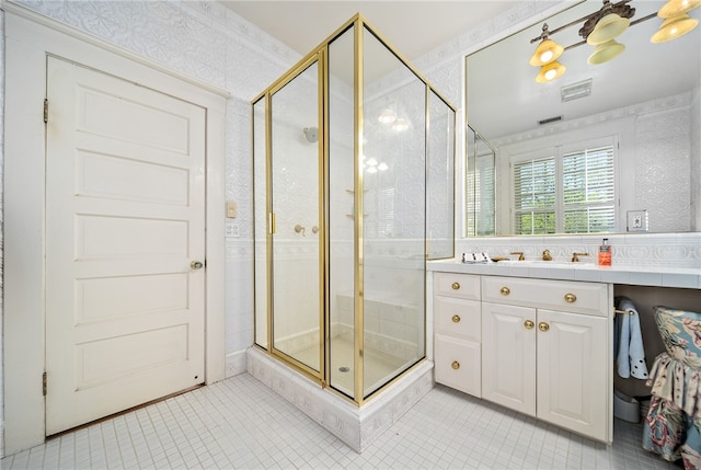 bathroom with tile patterned flooring, vanity, and walk in shower