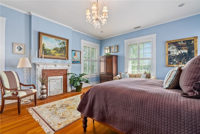 bedroom with multiple windows, crown molding, hardwood / wood-style floors, and a notable chandelier