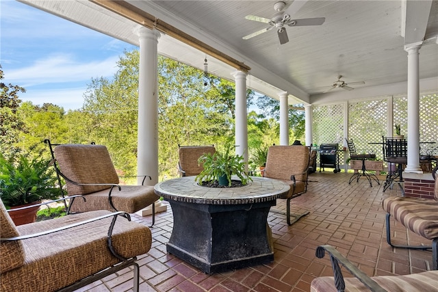 sunroom with decorative columns and ceiling fan