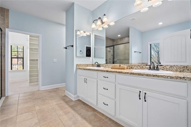 bathroom with visible vents, a sink, a shower stall, and a spacious closet