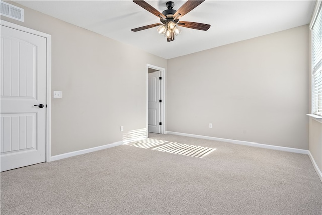 unfurnished room featuring a ceiling fan, carpet, visible vents, and baseboards