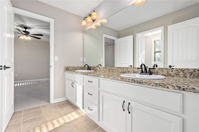 bathroom with double vanity, a sink, a ceiling fan, and baseboards