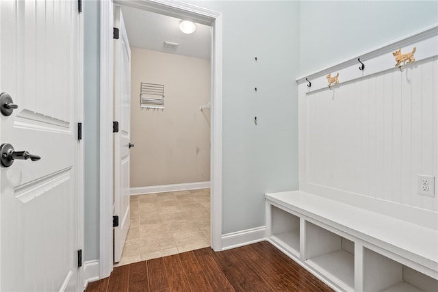 mudroom featuring dark wood-style flooring, a textured ceiling, and baseboards