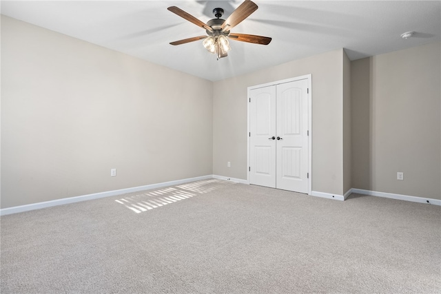 unfurnished bedroom with carpet floors, a ceiling fan, baseboards, and a closet