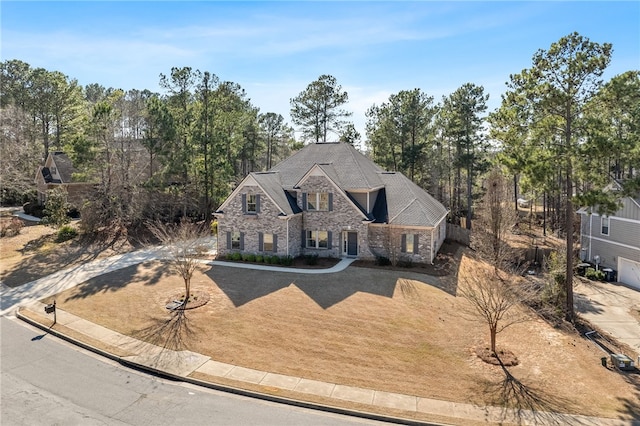 french country inspired facade with stone siding and driveway