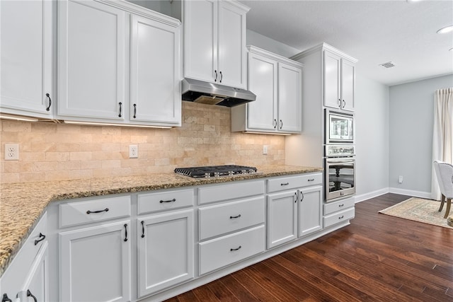 kitchen featuring under cabinet range hood, stainless steel appliances, visible vents, white cabinetry, and dark wood-style floors