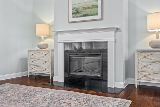 room details with a tiled fireplace, wood finished floors, and baseboards