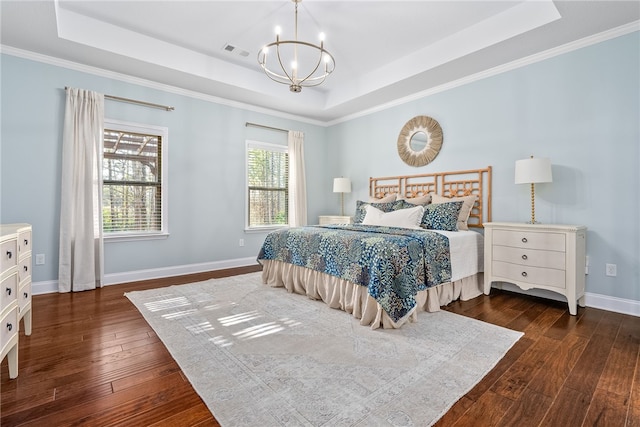 bedroom featuring a chandelier, a tray ceiling, dark wood-style flooring, and baseboards