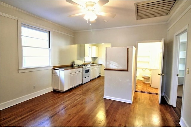 kitchen featuring crown molding, white range with gas cooktop, dark wood-type flooring, and white cabinets