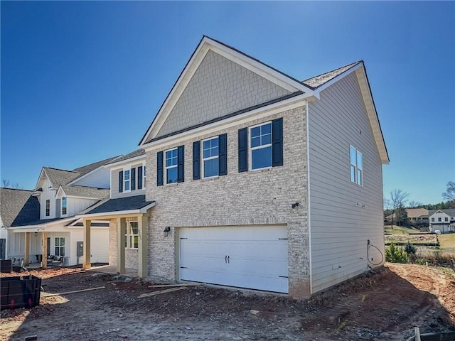 view of front of home with a garage, brick siding, and central AC unit