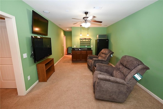 carpeted living room with bar and ceiling fan