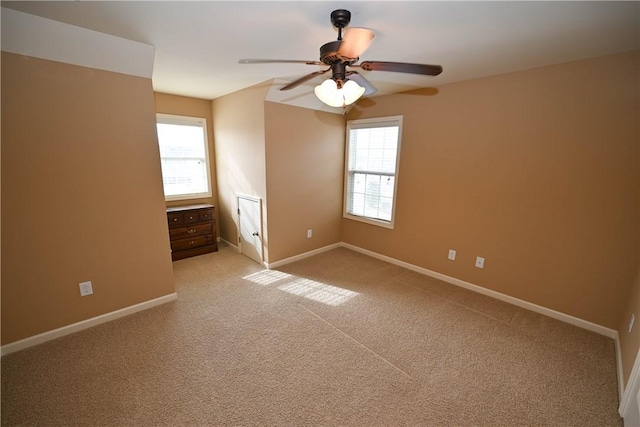 unfurnished bedroom featuring ceiling fan, light colored carpet, and multiple windows