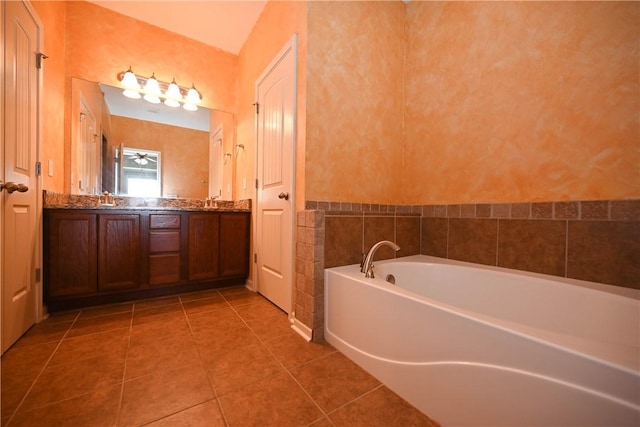 bathroom with tile patterned floors, a tub to relax in, and vanity