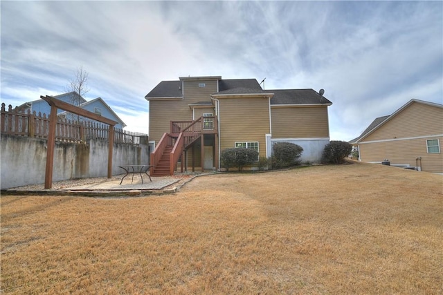 rear view of house with a yard and a patio area