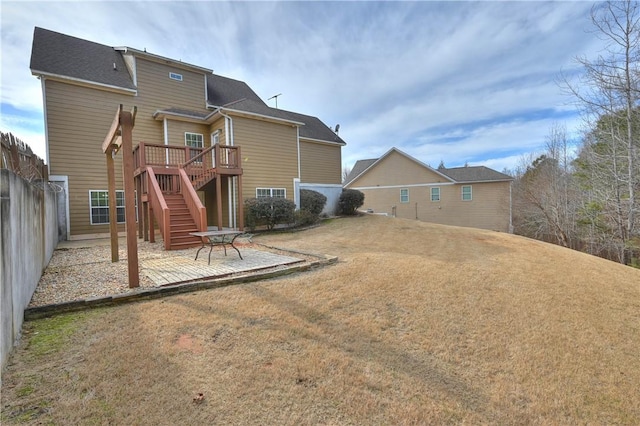 back of property with a wooden deck, a lawn, and a patio area