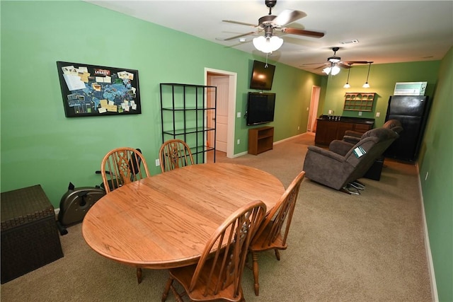 dining area featuring light carpet and ceiling fan