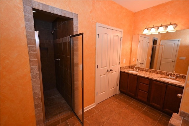 bathroom featuring tile patterned flooring, vanity, and a tile shower