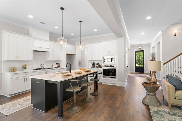kitchen featuring stainless steel appliances, a sink, ornamental molding, backsplash, and light countertops