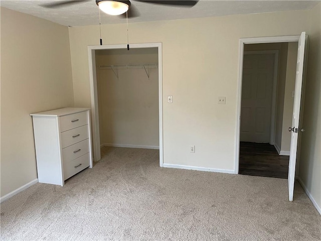 unfurnished bedroom with ceiling fan, a closet, and light carpet