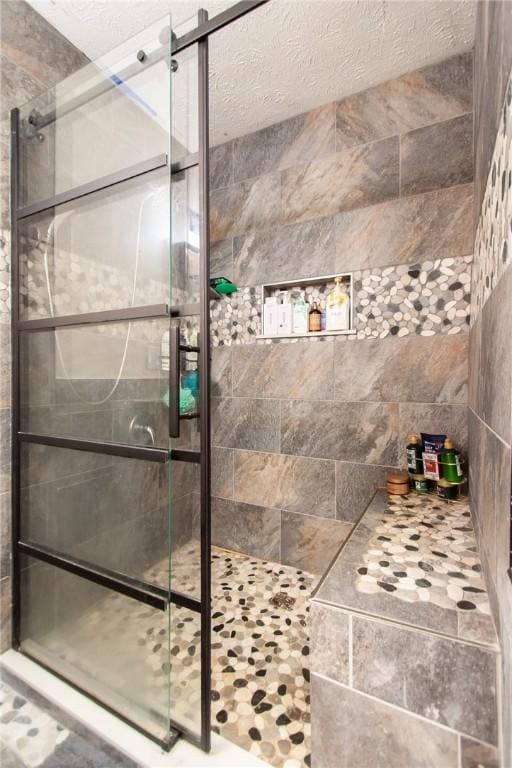 bathroom with a textured ceiling and walk in shower