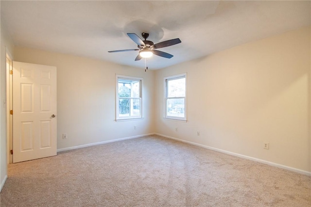 empty room featuring ceiling fan and light carpet