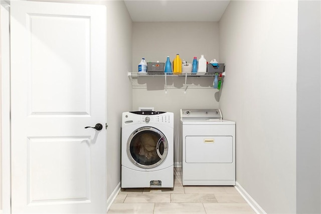 laundry room featuring washer and clothes dryer and light tile patterned floors