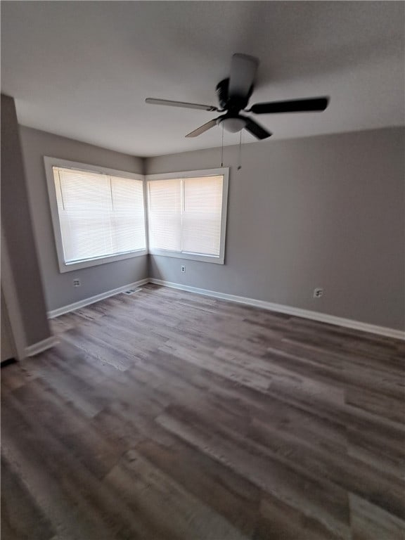 unfurnished room featuring a ceiling fan, baseboards, and wood finished floors