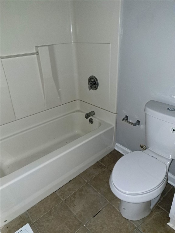 bathroom featuring toilet, washtub / shower combination, baseboards, and tile patterned floors