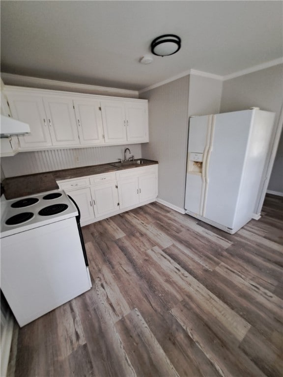 kitchen featuring white appliances, a sink, white cabinets, ornamental molding, and dark countertops